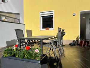 einen Tisch, Stühle und Blumen in einem Zimmer in der Unterkunft Gemütliches Reihenhaus mit Terrasse in Magdeburg