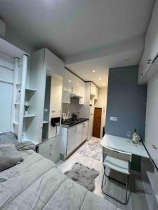 ein Schlafzimmer mit einem Bett und einem Schreibtisch sowie eine Küche in der Unterkunft Lovely Loft Bernabéu Madrid in Madrid