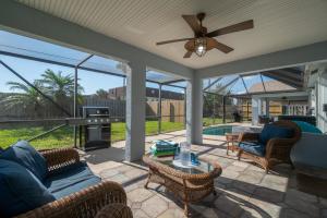 a screened in porch with a couch and a table at Oceanview Haven - 2BR Beach House with Patio Heated Pool Steps from Paradise Beach Park! in Melbourne