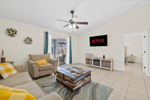 a living room with a couch and a table at Oceanview Haven - 2BR Beach House with Patio Heated Pool Steps from Paradise Beach Park! in Melbourne