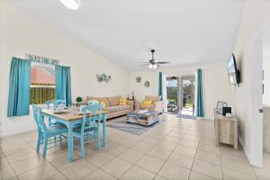 墨爾本的住宿－Oceanview Haven - 2BR Beach House with Patio Heated Pool Steps from Paradise Beach Park!，客厅配有桌椅和沙发
