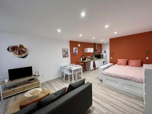 een slaapkamer met een bed en een woonkamer met een bank bij L'Orangeraie in Brioude