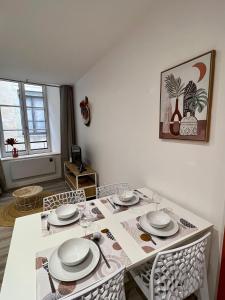 L'Orangeraie في بريود: غرفة طعام مع طاولة بيضاء وكراسي