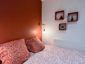 een slaapkamer met een bed met 2 kussens erop bij L'Orangeraie in Brioude