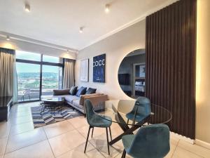 a living room with a couch and a table and chairs at 11 Floors in the Sky - Luxurious 1 Bedroom in Pretoria