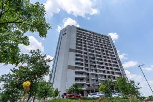 a tall white building with trees in front of it at 11 Floors in the Sky - Luxurious 1 Bedroom in Pretoria