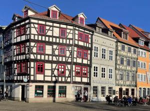 a large black and white building with red windows at Appartement DOM II - Erfurt Domplatz in Erfurt