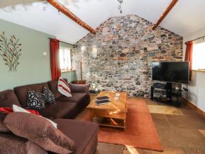 a living room with a couch and a tv at Sonya's Cottage in Anthorn