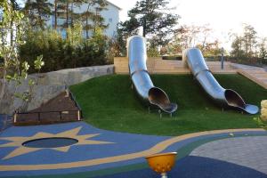 a playground with two slides on the grass at Fully furnished room for rent in Märsta in Märsta