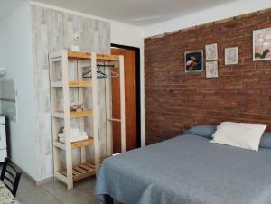 - une chambre avec un lit et un mur en briques dans l'établissement El Poblador, à Santa Rosa
