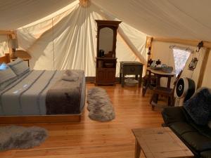 Idleyld ParkUmpqua's Last Resort - Wilderness Cabins, RV Park & Glamping的帐篷里有一张床的卧室