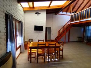 a dining room with a table and chairs and a television at Casa Peral in El Bolsón