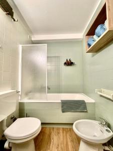 een badkamer met een toilet, een wastafel en een bad bij Pila 29 in Pila