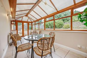 a dining room with a glass table and chairs at Beautiful 4-5 bedroom village house with rural views in Salford