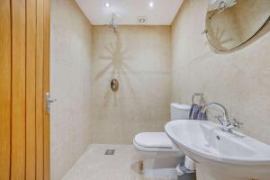 a bathroom with a toilet and a sink and a mirror at Beautiful 4-5 bedroom village house with rural views in Salford +26 photos