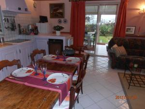 a living room with two tables and a kitchen at Gîte Tuyaret in Oloron-Sainte-Marie