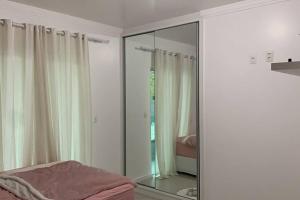1 dormitorio con espejo y 1 cama. en Casa perfeita na Praia da Lagoinha, en Florianópolis