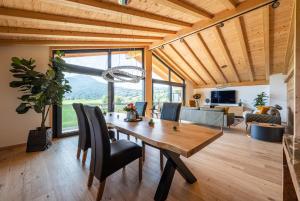 una sala da pranzo con tavolo e sedie in legno di Alpine Lifestyle Lodge a Oberstdorf