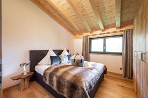 a bedroom with a large bed with a wooden ceiling at Alpine Lifestyle Lodge in Oberstdorf