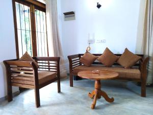 a living room with a couch and a table at SKY Clouds Residencies Hikkaduwa in Hikkaduwa