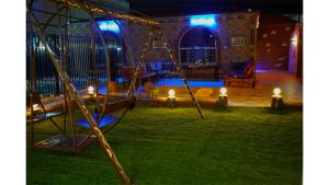 a swing set in a yard at night at شاليهات دي لا كروز in Makkah