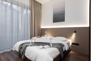 a bedroom with a bed with two books on it at cohost I New Bastėja Life Apartments w-Garage Prkg & Self Check-in in Vilnius