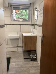 baño pequeño con lavabo y ventana en Au Talhorn chez Marc, en Fellering