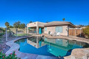 a swimming pool in front of a house at Goodyear Desert Oasis with Patio and Game Room! in Goodyear