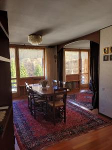 une salle à manger avec une table et des chaises sur un tapis dans l'établissement Over The Snow Apartment, à Borgata Sestriere