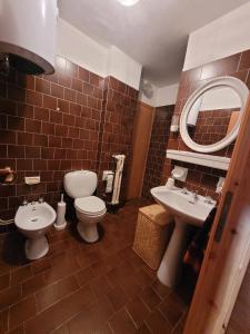 a bathroom with two toilets and a sink and a mirror at Over The Snow Apartment in Borgata Sestriere