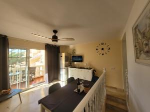 a living room with a table and a clock on the wall at Apartament CALETA in Caleta De Fuste