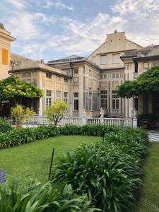 Palazzo Penco Apartment في جينوا: منزل كبير مع حديقة أمامه