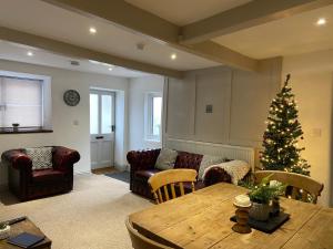 a living room with a christmas tree and a table at Grade II Listed 2 Bed Cottage with Free Parking in King's Lynn