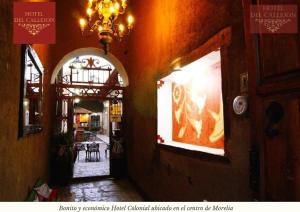 a hallway of a building with a chandelier and a dining room at Hotel Morelia Callejón in Morelia