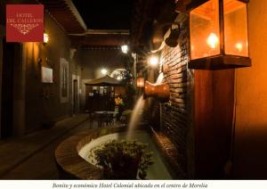 una fuente de agua pegada a una pared de ladrillo con un edificio en Hotel Morelia Callejón en Morelia