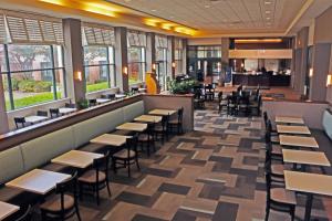 um restaurante com mesas e cadeiras e um bar em Quality Suites Lake Wright Norfolk Airport em Norfolk