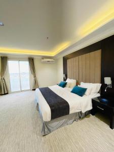 Großes Hotelzimmer mit einem großen Bett mit blauen Kissen in der Unterkunft فندق وريف الشرق in Sarat Abidah
