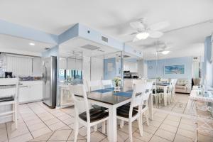 cocina y comedor con mesa y sillas en Sunbird 1106W en Panama City Beach
