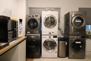 uma cozinha com 3 máquinas de lavar roupa e uma máquina de lavar e secar roupa em The garden hotel em Seul
