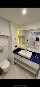 a bathroom with a toilet and a sink and a mirror at Batumi Rest Apartament in Batumi