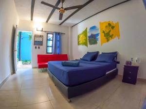 1 dormitorio con 1 cama azul y 1 sofá rojo en Dreamer Santa Marta, en Santa Marta