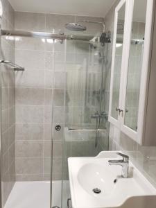 Charming apartment Chambourcy في تشامبوركي: حمام مع دش زجاجي ومغسلة