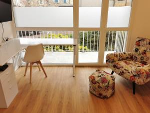 a living room with a chair and a desk and windows at Charming apartment Chambourcy in Chambourcy