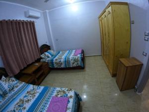 a room with two beds and a closet in it at Cozy Apartment Freedom in Hurghada