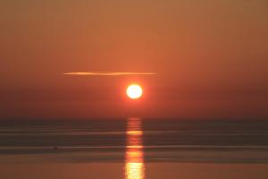 a sunset over the ocean with a cloud in the sky at Hotel Capizzo in Ischia
