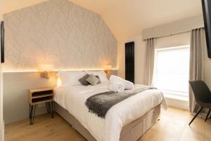 Un dormitorio con una cama grande y una ventana en The Roost on Rock Road, en Barry