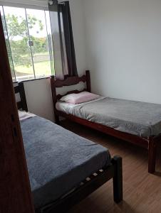 2 Betten in einem Zimmer mit Fenster in der Unterkunft Casa enteira con piscina compartilhada in Búzios