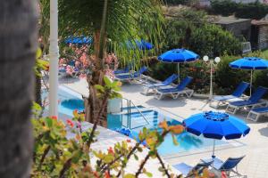 a swimming pool with blue chairs and umbrellas at Hotel Capizzo in Ischia