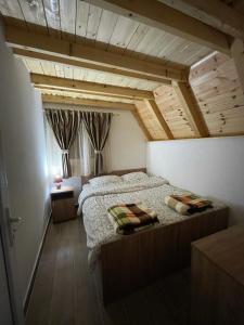 a bedroom with a bed and a wooden ceiling at Planinska kuca ANDJELA 1 in Mitrovac