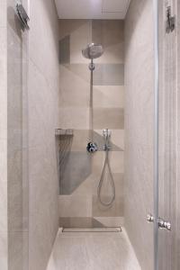 a shower with a glass door in a bathroom at cohost I New Bastėja Life Apartments w-Garage Prkg & Self Check-in in Vilnius